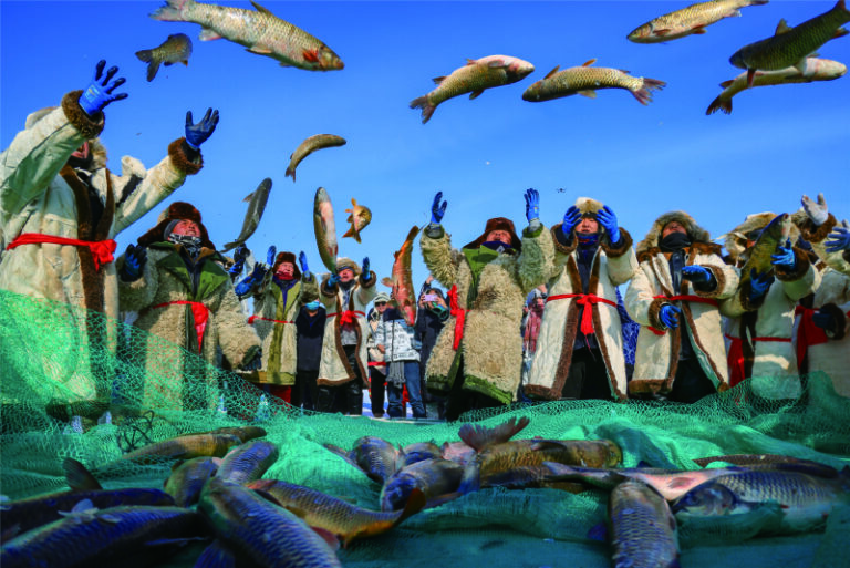 Fishermen display the big fish they caught in the first net of the new year on the ice of Bosten Lake. Photo by Nian Lei