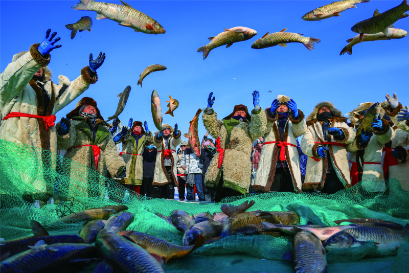 Fishermen display the big fish they caught in the first net of the new year on the ice of Bosten Lake. Photo by Nian Lei